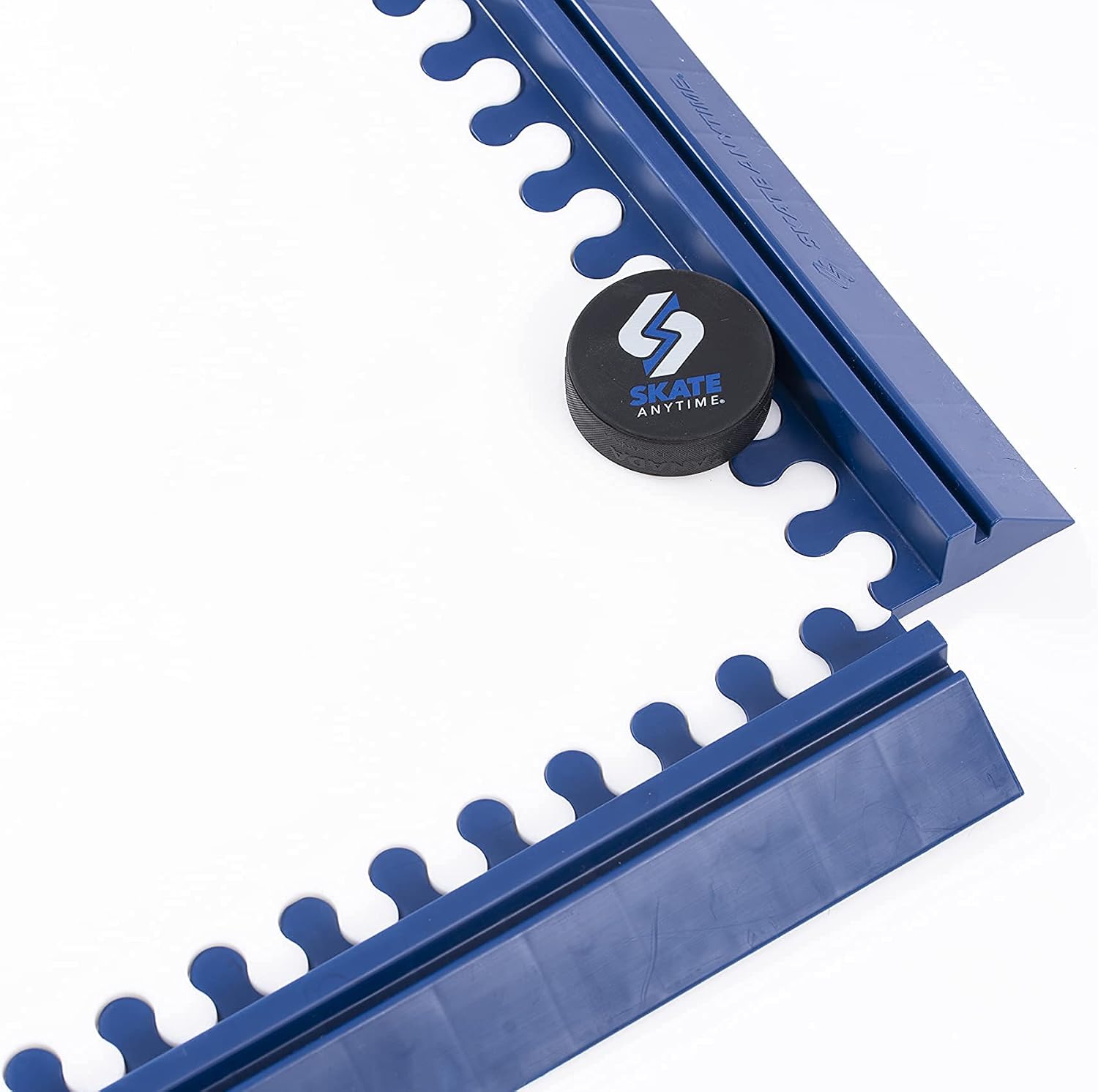 Blue plastic hockey stick guard with interlocking teeth along the edges, shown on a white background with a black hockey puck featuring the Skate Anytime logo.